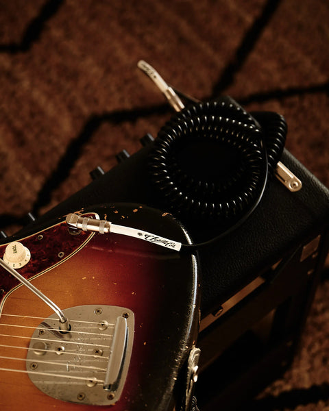 Black coiled guitar cable on amplifier