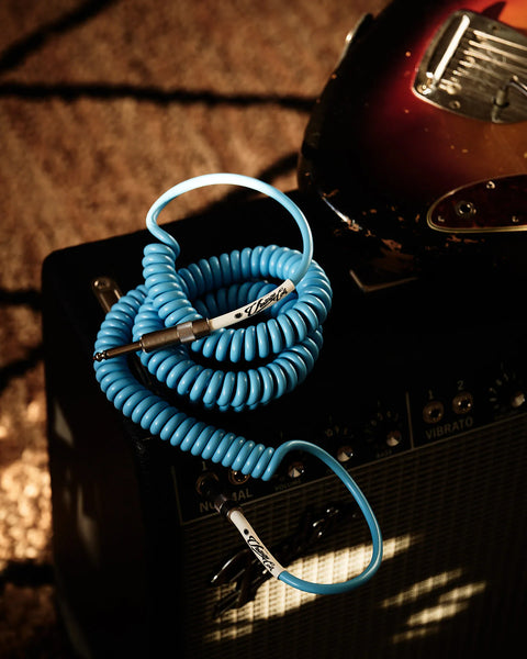 Blue curly guitar cable plugged into amp