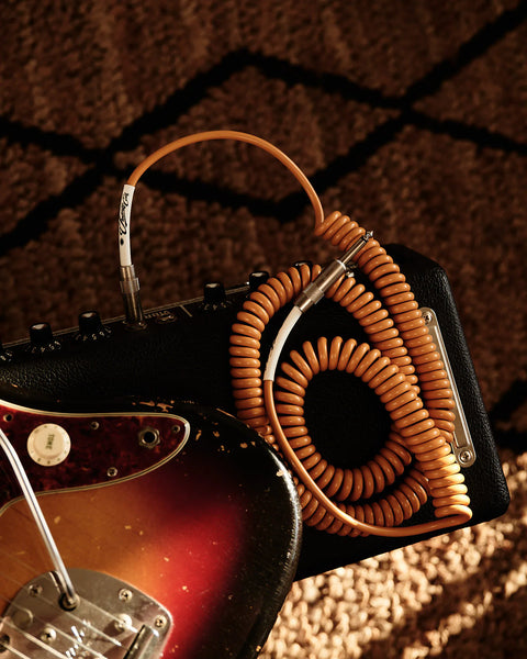 Caramel coiled guitar cable with electric guitar amp