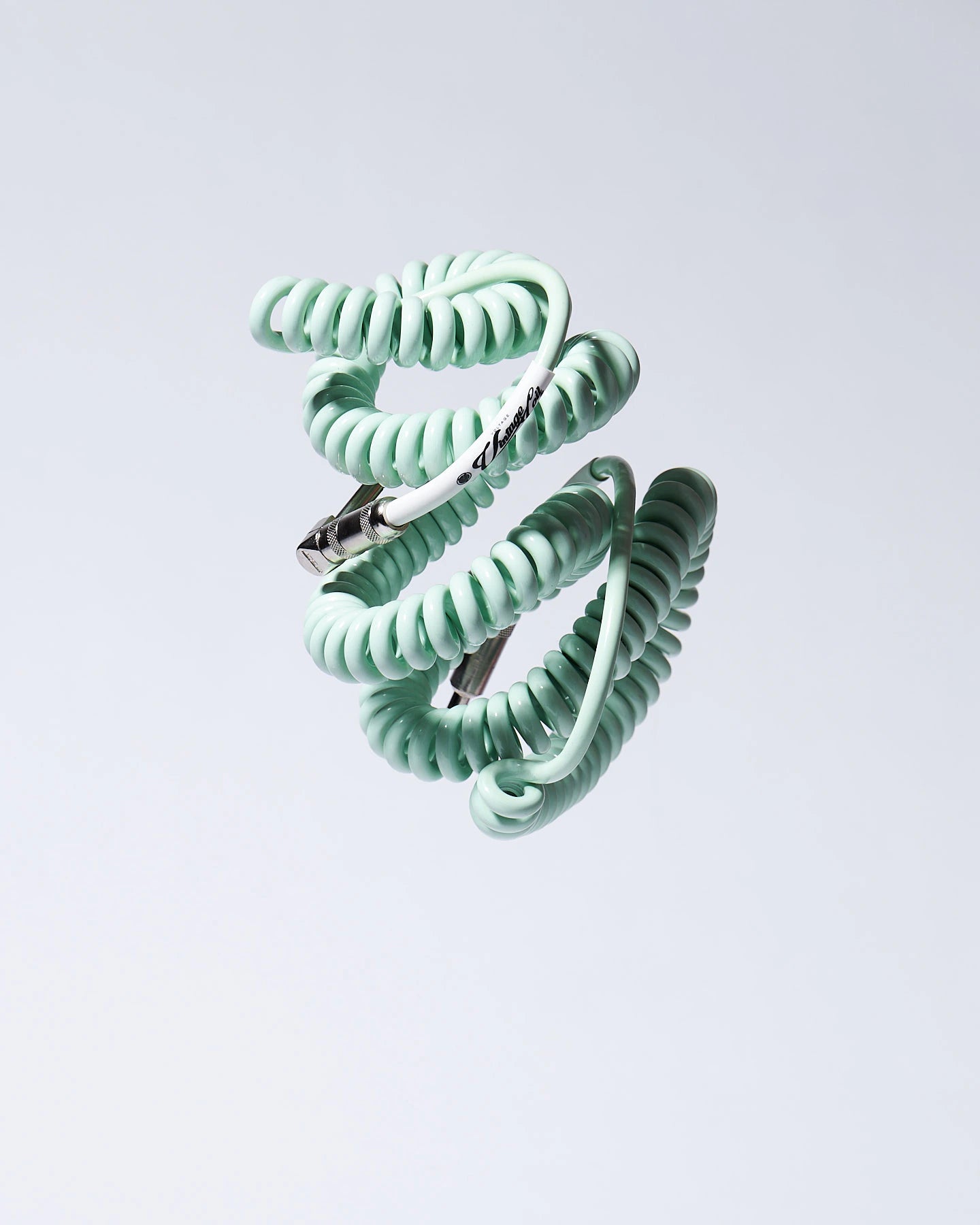 Surf Green coiled guitar cable flying product photo Voltage Vintage Coil®