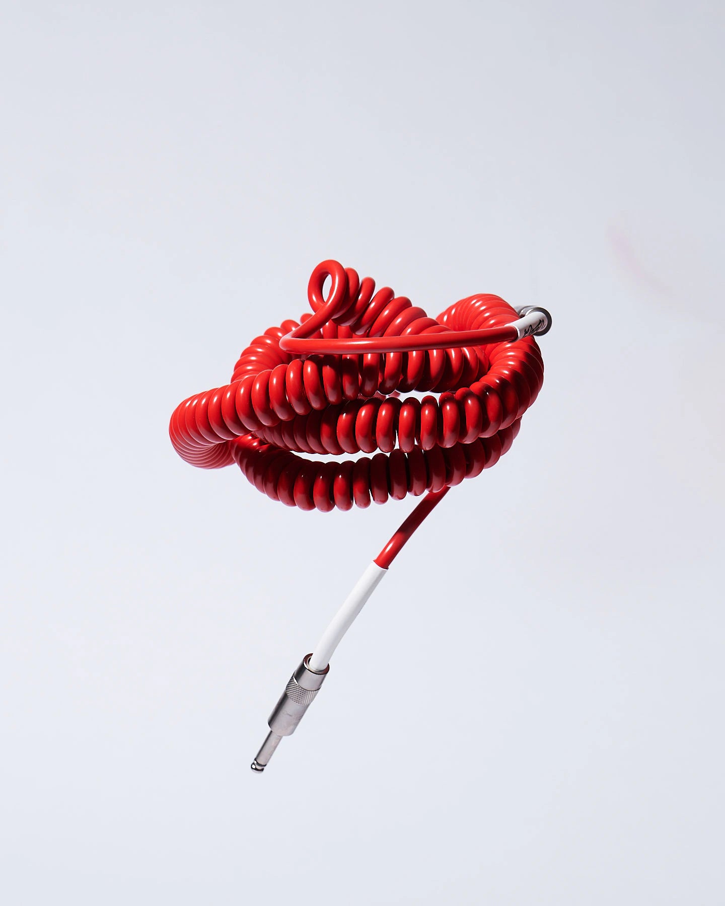 Red coiled guitar cable flying product photo Voltage Vintage Coil®