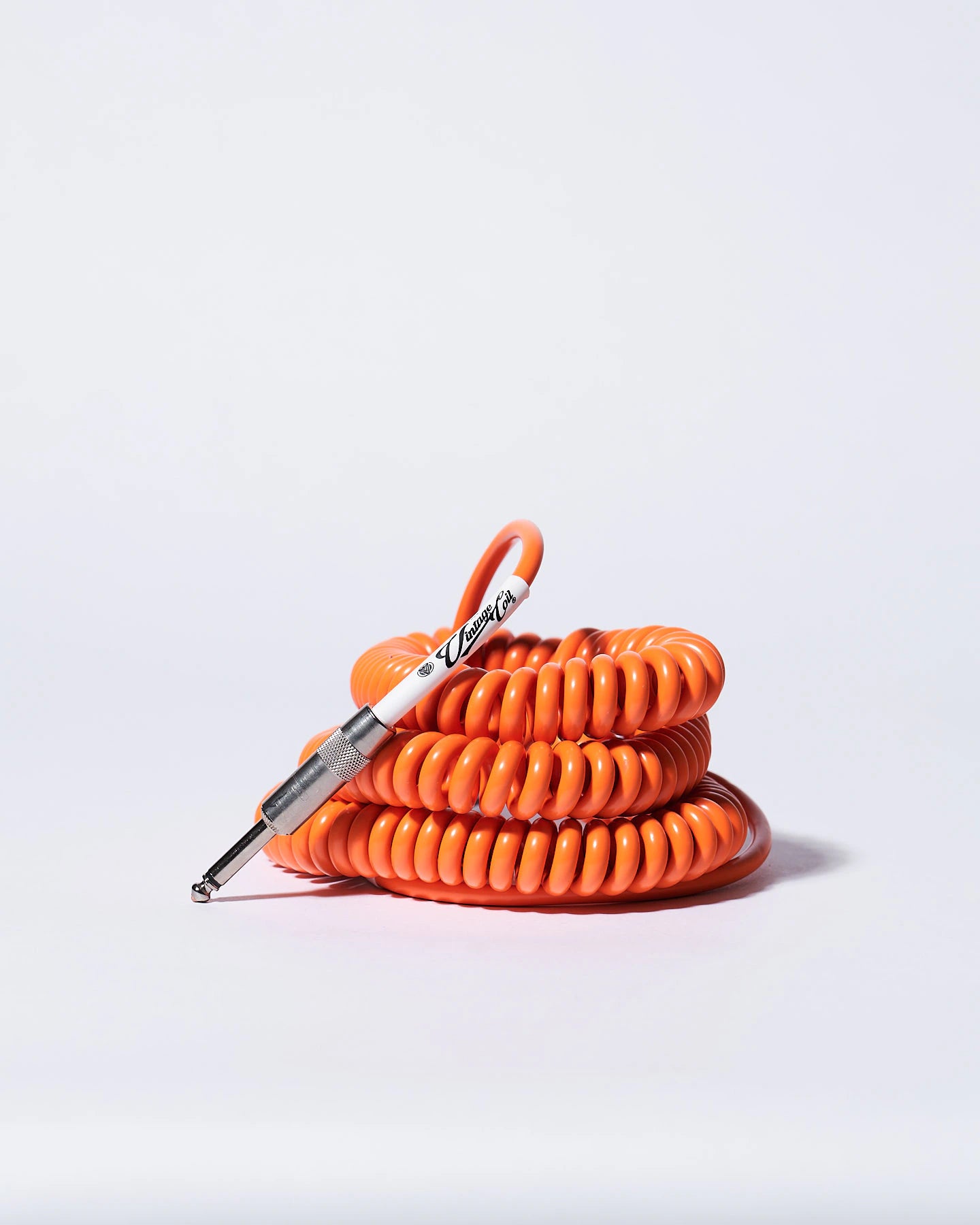 Orange coiled guitar cable flying product photo Voltage Vintage Coil®