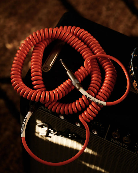 Orange coiled guitar cable with amplifier