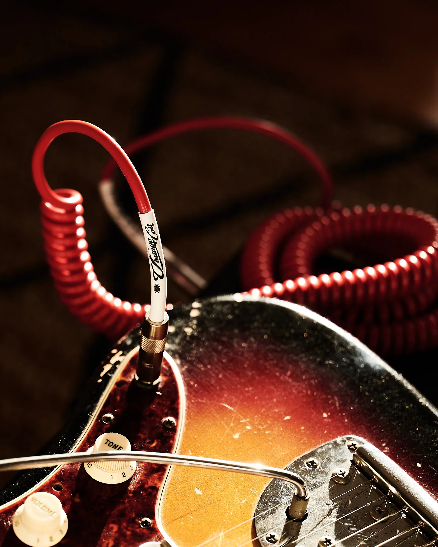 Red curly guitar cable with electric guitars